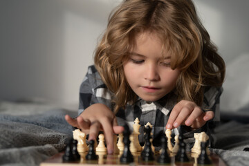 Little boy are playing chess at home. Child think about chess game. Intelligent, smart and clever school kid pupil. Games for brain intelligence concept. - 786877530