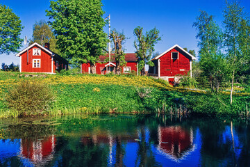 Idyllic view with red cottages by a lake in summer