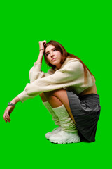 Woman Sitting on Ground in Front of Green Screen