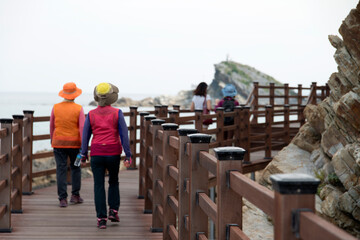 View of the tourists on the wooden footpath at the seaside