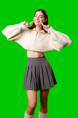 Smiling Young Woman Posing in Casual Clothing Against a Green Background