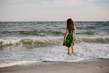 Girl standing in ocean wearing sundress