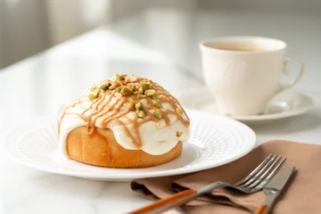 Fotobehang Cinnamon roll bun with icing on plate © fotofabrika