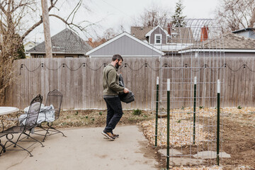 Man covers plants with bedsheet to protect them from snowstorm