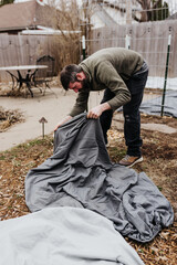 Man covers plants with bedsheet to protect them from snowstorm
