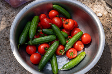 A bowl of tomatoes and cucumbers is sitting on a table