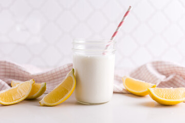 Refreshing lemon milkshake in a mason jar with striped straw