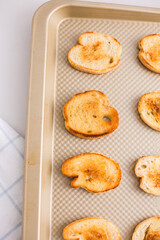 Toasted crostini on a baking sheet
