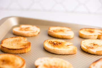 Toasted crostini on a baking sheet