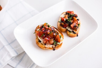 Balsamic glaze topped bruschetta on a plate