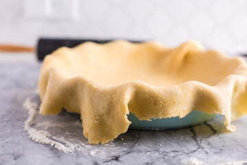 Pie crust hanging over the side of pie dish
