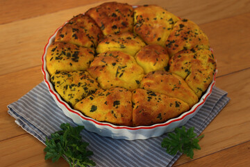 Turmeric curcuma and parsley bread . Healthy turmeric Bread in a cake pan on a gray striped napkin on wooden table