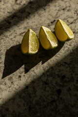 Lime wedges casting shadows on marbled surface