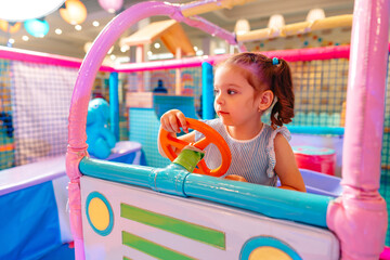 Little Girl Playing With Toy Car in Play Area