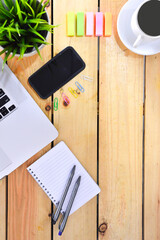 Flat lay design of work desk with laptop notebook, smartphone, pen, sticky note and notepad on wooden background.