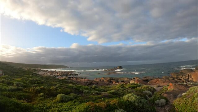 Time lapse shot of beautiful sunrise in River Mouth, Margaret River region, Western Australia. Flying dense dark clouds over coast and ocean. Wide shot.