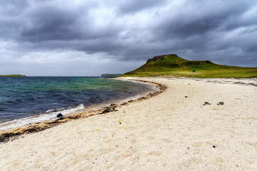 Plage de sable fin de Coral Beach sur l'île de Skye en Ecosse avec eaux turquoises et ciel menaçant au printemps