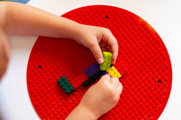 Child Engaged in Creative Play With Colorful Building Blocks on a Round Base