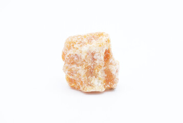 Macro focused raw vibrant orange, calcite stone, bright orange carbonate crystal gemstone isolated on a white surface background. is believed to be a great stone for balance.