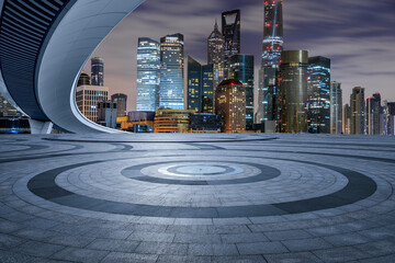 Round square floor and bridge wih modern city buildings at night in Shanghai
