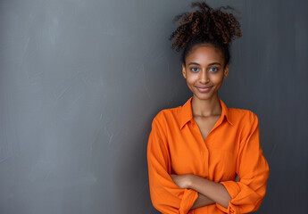 Vibrant Young Woman with Curly Hair Standing Arms Crossed in Orange - 786904348