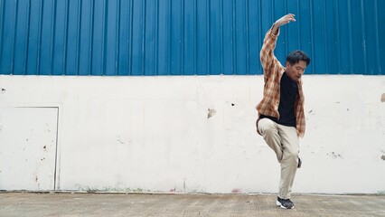 Hispanic funny choreographer dancing in hip hop style. Young happy break dancer perform b-boy dance. Motion shot of funny man practicing street dancing. Outdoor sport 2024. Modern dance. Endeavor.