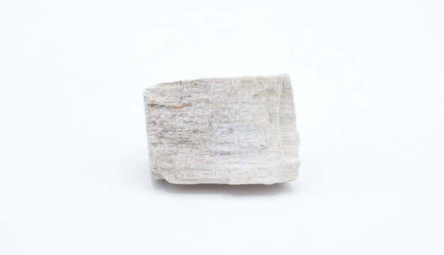 Cut out gypsum satin spar mineral rock isolated on white background. Gypsum is a soft sulfate mineral composed of calcium sulfate dihydrate, with the chemical formula CaSO 4·2H2O