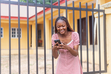 Beautiful African Woman Using Phone Beside Building