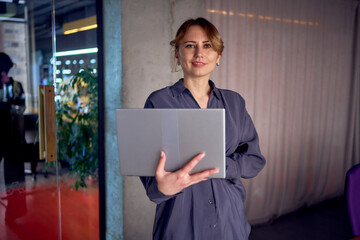 a beautiful middle age concentrated business woman wearing gray shirt and using laptop while...
