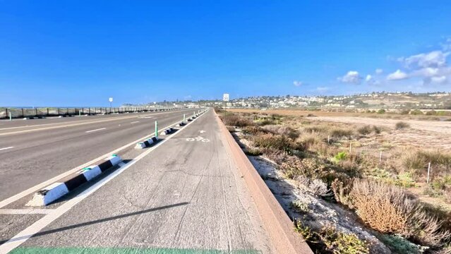 Immersive point of view footage of a cyclist pedaling along the a bike path parallel to the Pacific Coast Highway 101 near Escondido, California