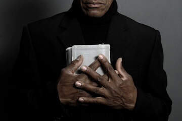 praying to God with hands together on grey black background with people stock image stock photo	