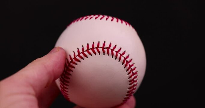 white baseball ball tied with red thread, a real round baseball ball close-up