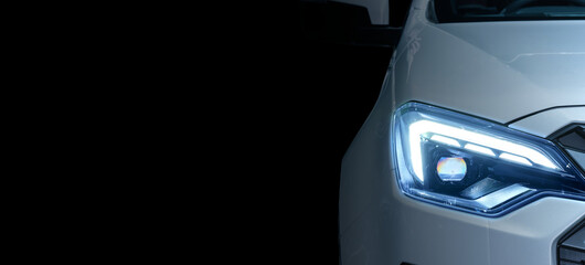 Close-up front left eyesight headlight with LED xenon light of white luxury modern car on black...