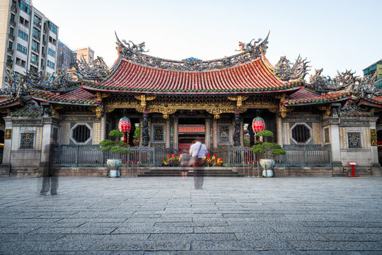 Longshan Temple, well known Chinese temple in Taiwan, long exposure shot for people movement, people pay respect to Buddha outside temple, vintage traditional place