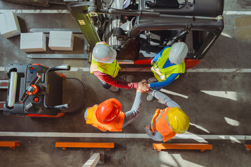 Top view successful team of workers wear hard hats vests, work wear joining hands together, teamwork