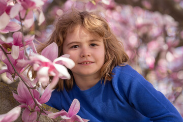 Kid in spring cherry blossom park. Happy childhood. Spring holidays. Adorable boy in spring garden. Cute little kid boy under a blossom flowering tree. Portrait of beautiful kid in spring garden. - 786930180