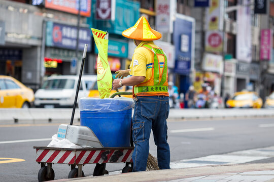 Road sweeper on his outstanding costume by street in Taipei, Taiwan, filter effect, street janitor in uniform