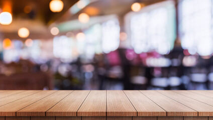 Empty wooden table top with lights bokeh on blur restaurant background.