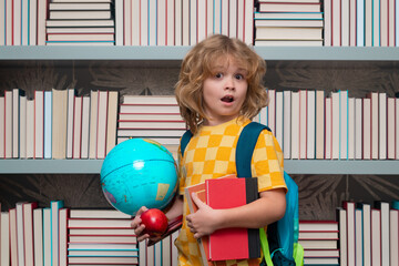 School boy with world globe and books. School child student learning in class, study english language at school. Elementary school child. Portrait of funny pupil learning.