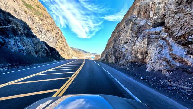Immersive, establishment point of view of a cruise down the classic Pacific Coast Highway 101 to Malibu, California.  Enjoy scenes of sun, sand and surf below the bright blue skies.