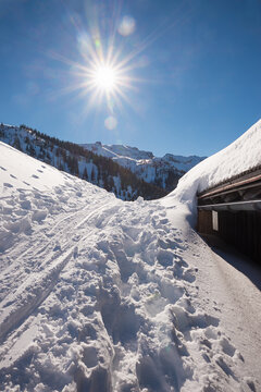 winter landscape tyrol, skiing tracks and snowbound hut, bright sunshine