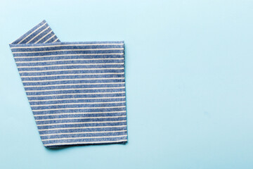 top view with blue kitchen napkin isolated on table background. Folded cloth for mockup with copy space, Flat lay. Minimal style