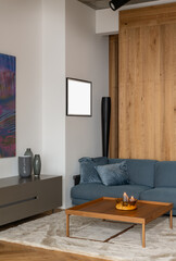 Living room with blue couch, wooden coffee table on hardwood floor