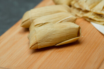 Central American tradition: savory tamales wrapped in corn leaves, served with creamy goodness, a...