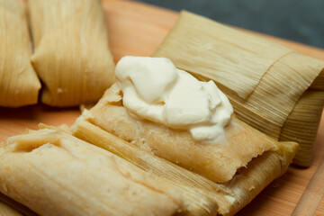 Central American tradition: savory tamales wrapped in corn leaves, served with creamy goodness, a taste of El Salvador