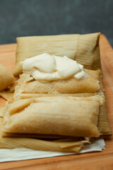 Central American tradition: savory tamales wrapped in corn leaves, served with creamy goodness, a taste of El Salvador