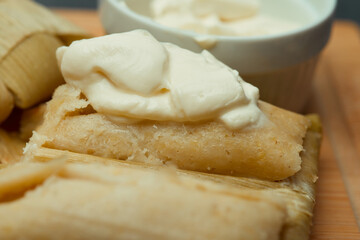 Central American tradition: savory tamales wrapped in corn leaves, served with creamy goodness, a taste of El Salvador