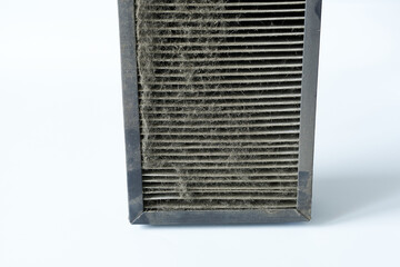 A dirty air filter on a white background. 