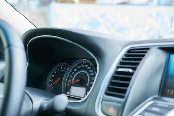 A modern car interior, close-up. Steering wheel and speedometer.