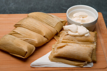Central American tradition: savory tamales wrapped in corn leaves, served with creamy goodness, a taste of El Salvador
